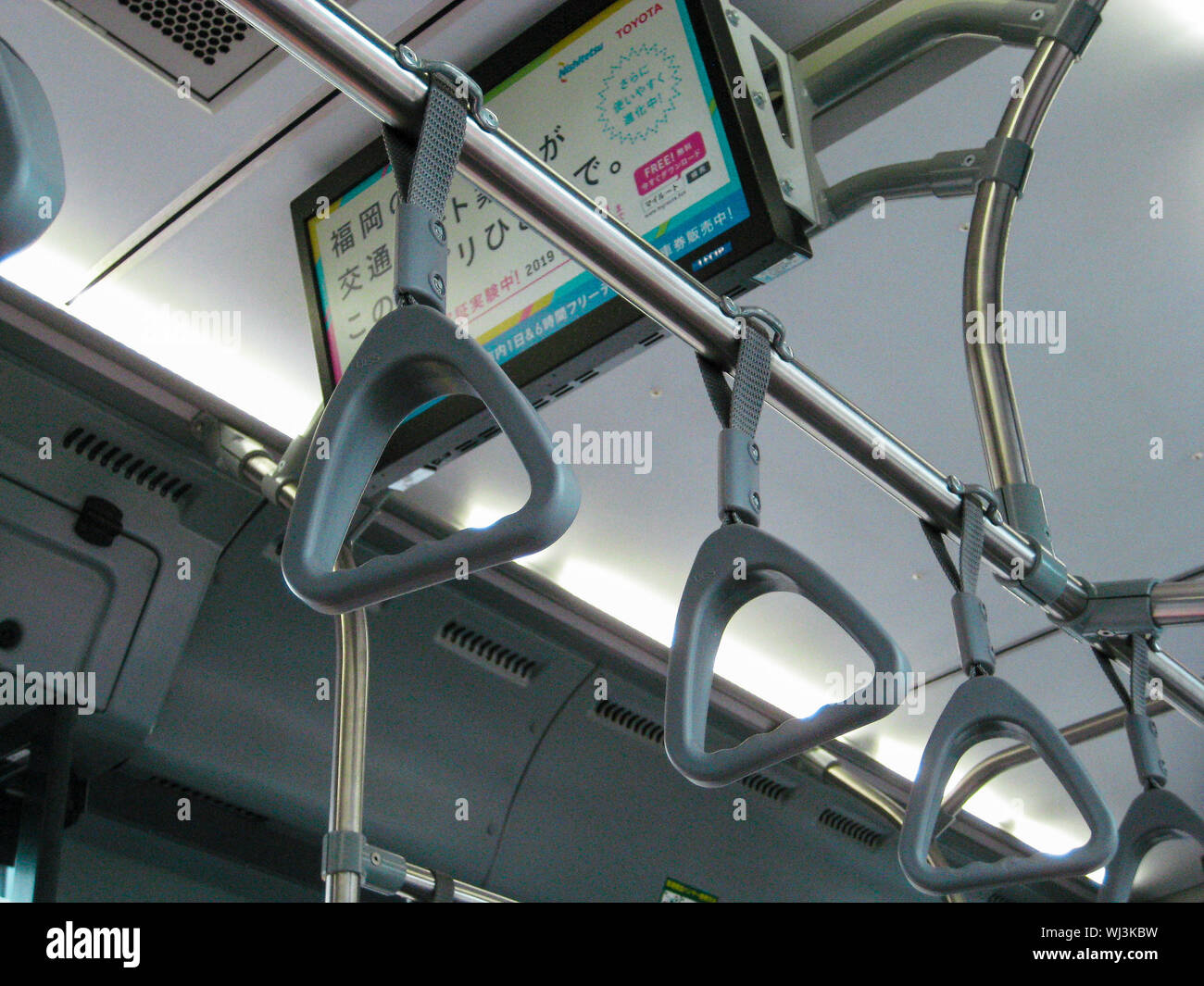handrails on japanese bus hanging from the roof with japanese sign in ...