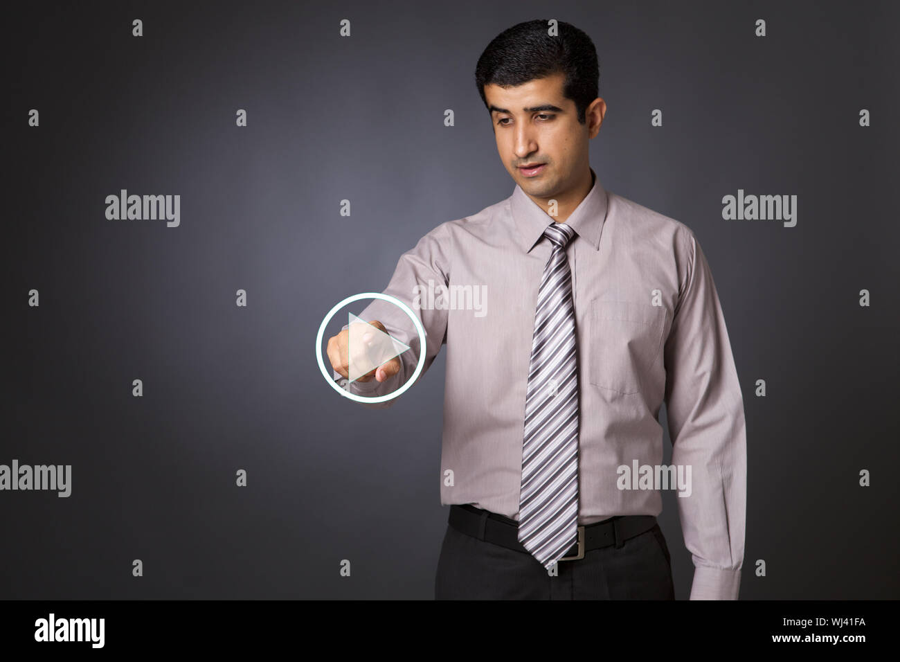 Businessman pressing startplay button on virtual screen Stock Photo
