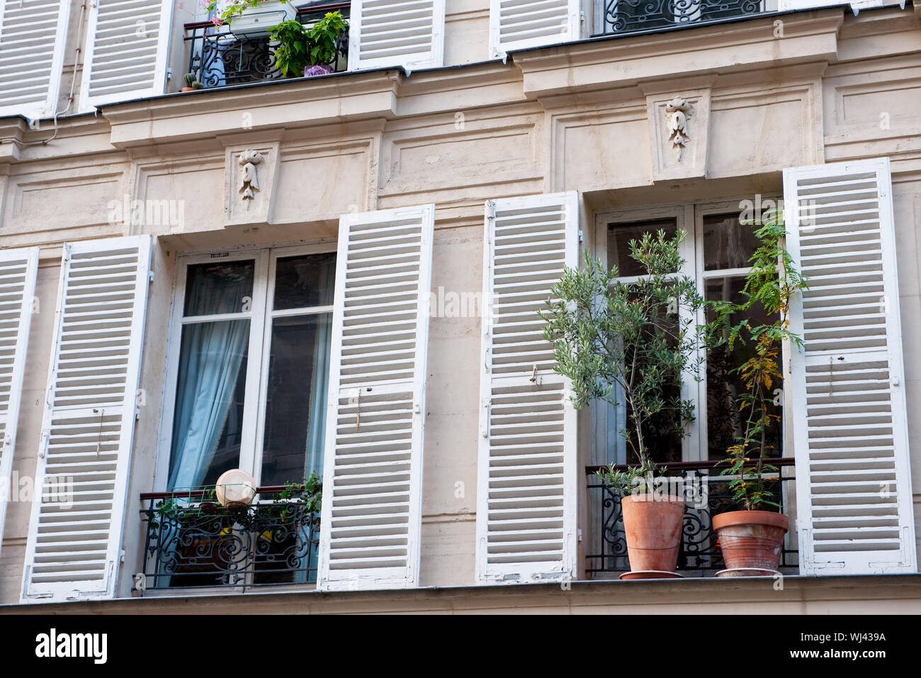 Typical French windows with balconies and blinds in Paris Stock Photo