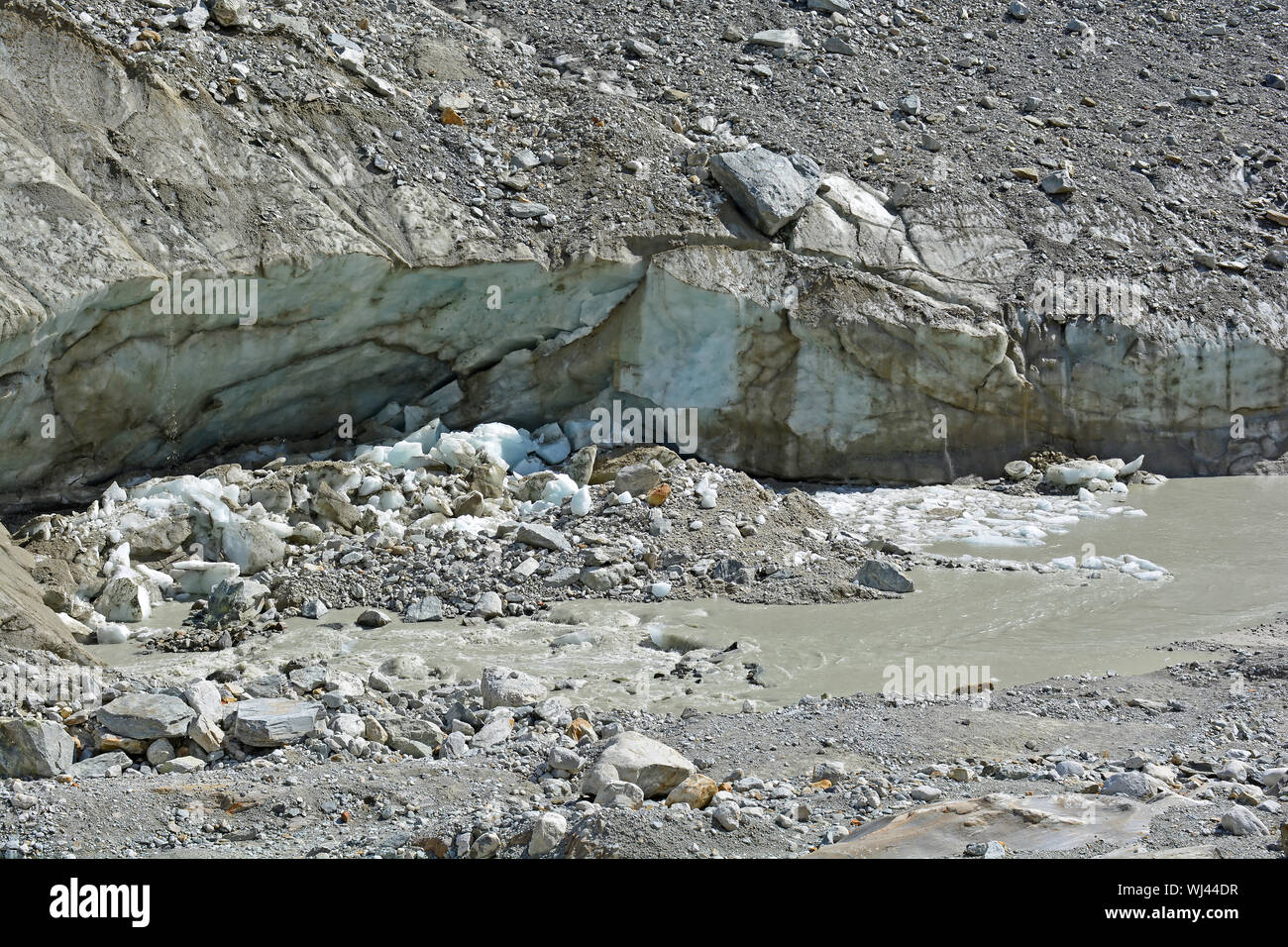 Collapsing ice cave in a glacier dug out by a meltwater river and melting due to a warming climate Stock Photo