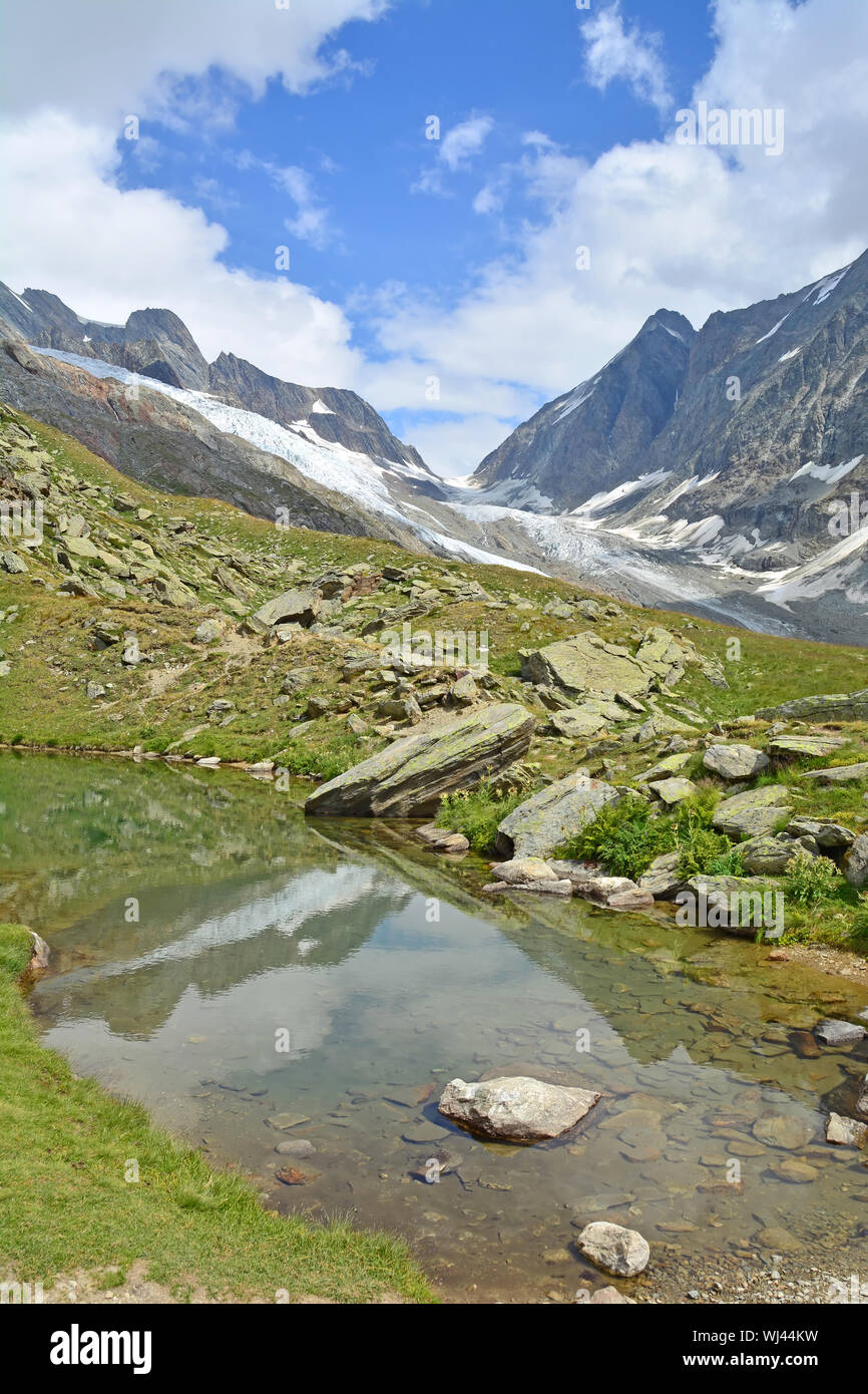 The Lotschenlucke Pass with the Hollandia Hut above it. In the foreground the Annensee pool. In the Bernese Alps, Switzerland Stock Photo