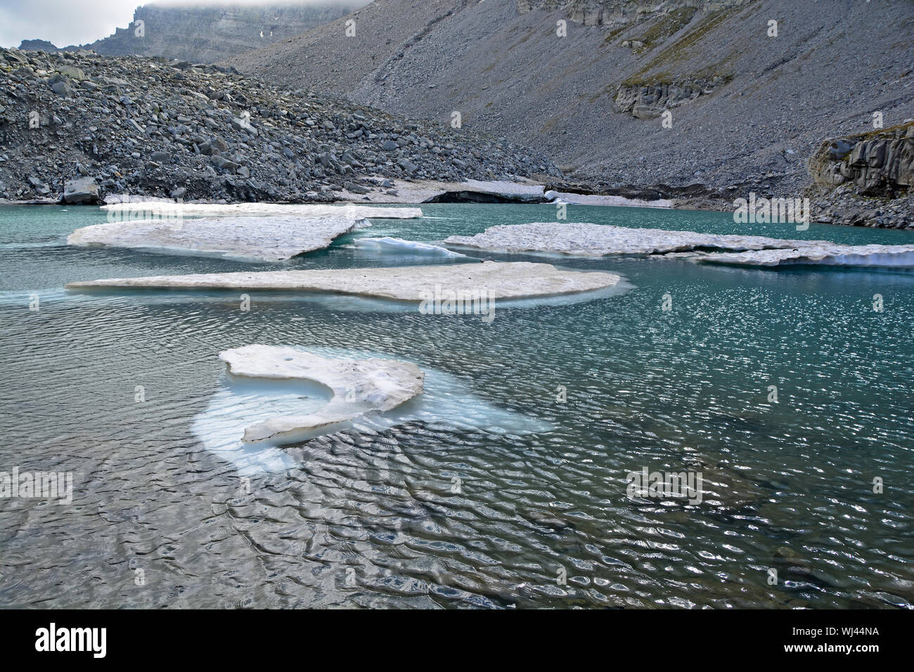 Icebergs broken off from a glacier in a glacial lake in the mountains as the climate warms. Stock Photo