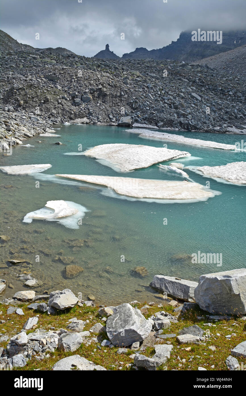 The Chriegalp Pass on the border between Switzerland and Italy with a glacial lake and small icebergs Stock Photo
