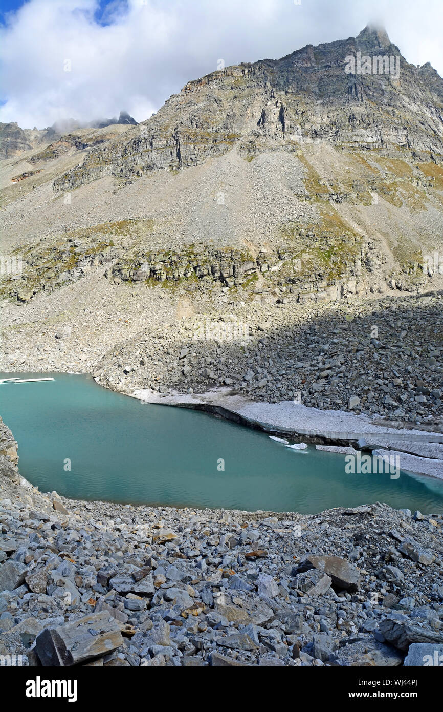 Glacial lake in the mountains with slabs of ice broken away as the climate warms and the glacier melts Stock Photo
