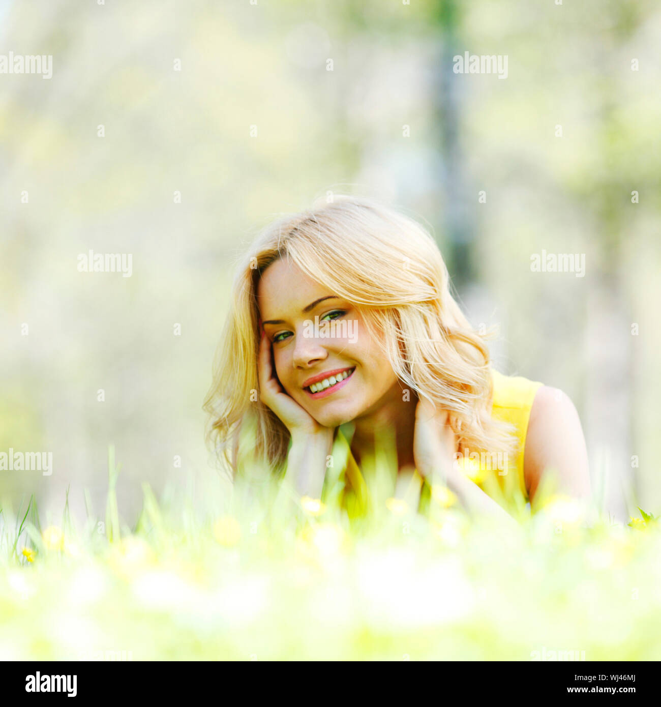 Happy young woman lying on grass Stock Photo - Alamy
