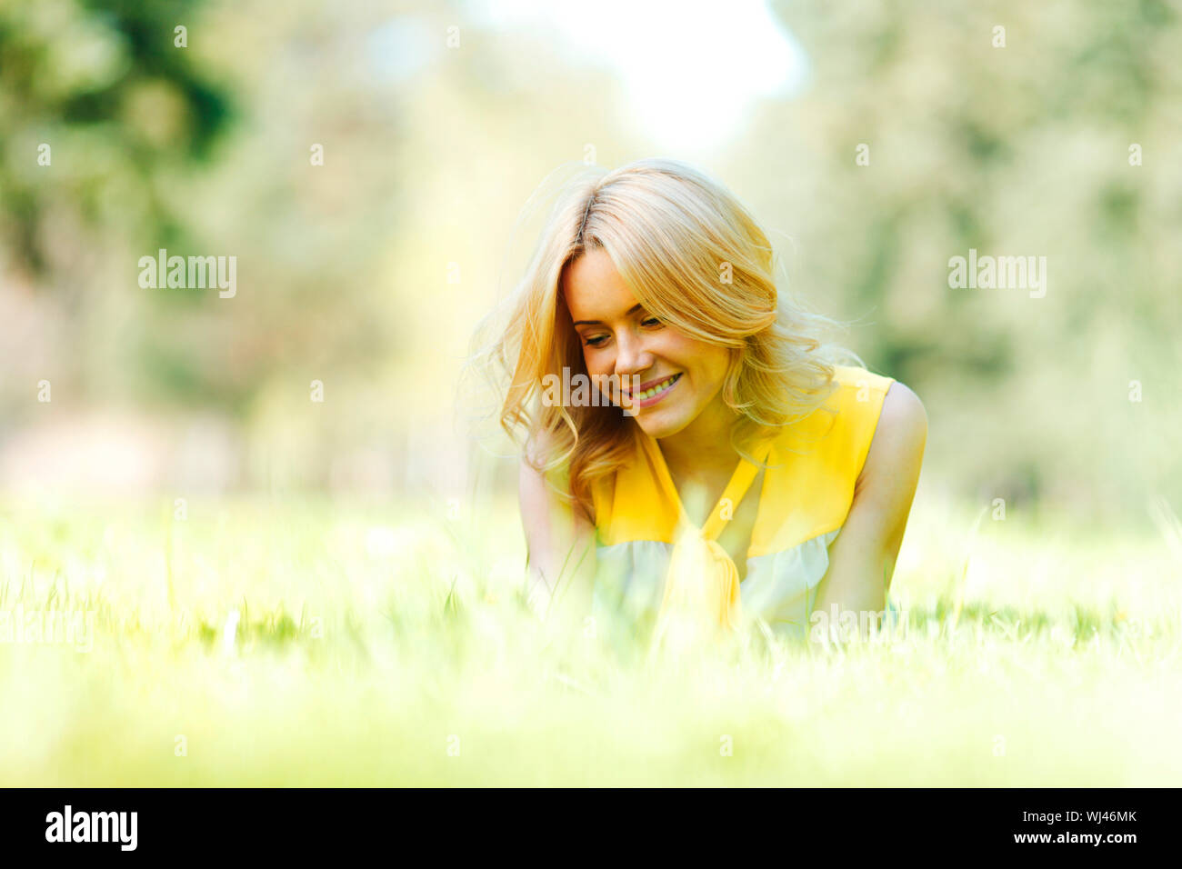 Happy young woman lying on grass Stock Photo - Alamy