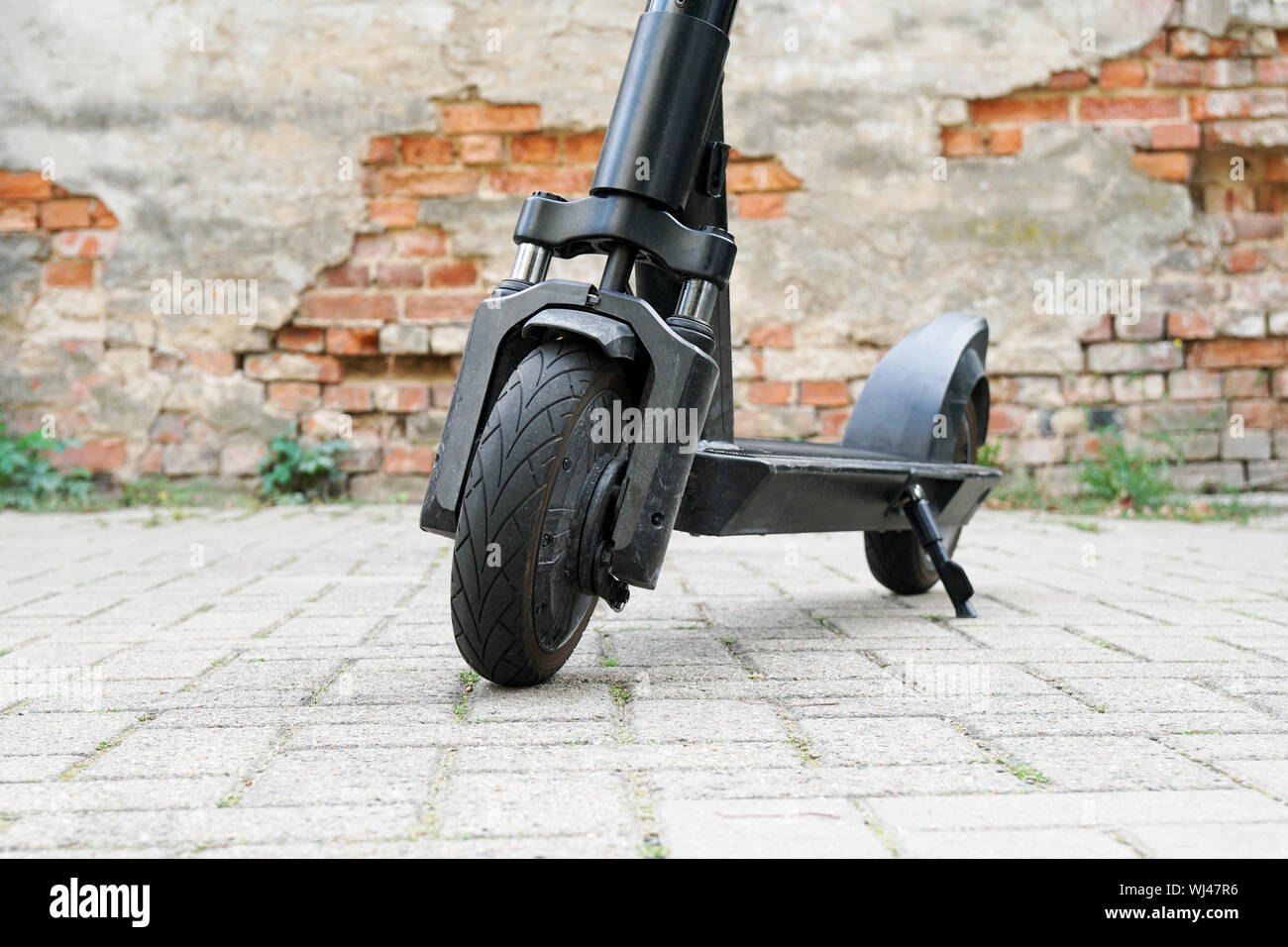 Electric kick scooter or e-scooter parked on pavement - e-mobility or micro-mobility trend Stock Photo