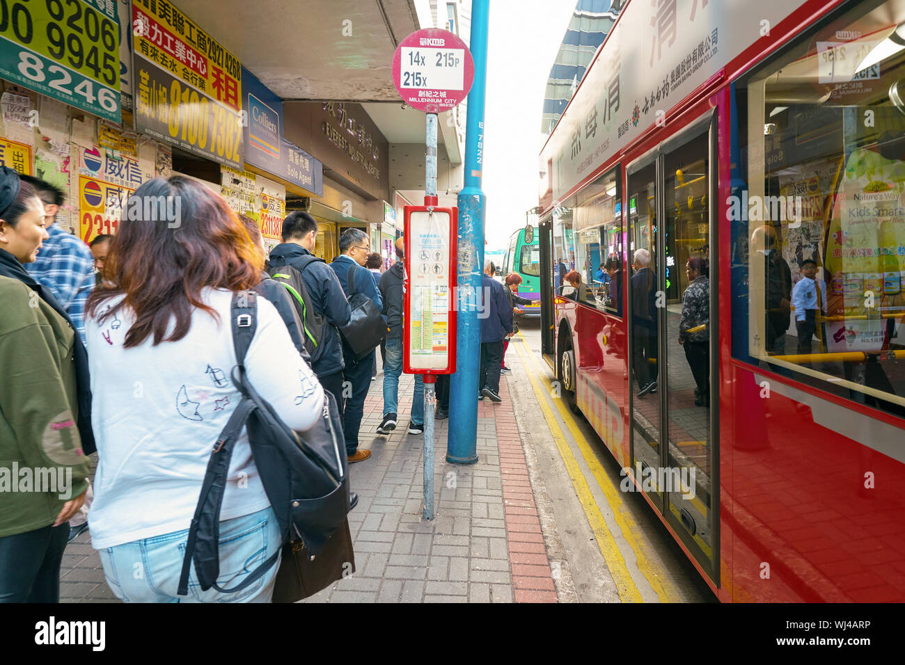 HONG KONG, CHINA - CIRCA JANUARY, 2019: people boarding a bus at a bus stop in Hong Kong. Stock Photo
