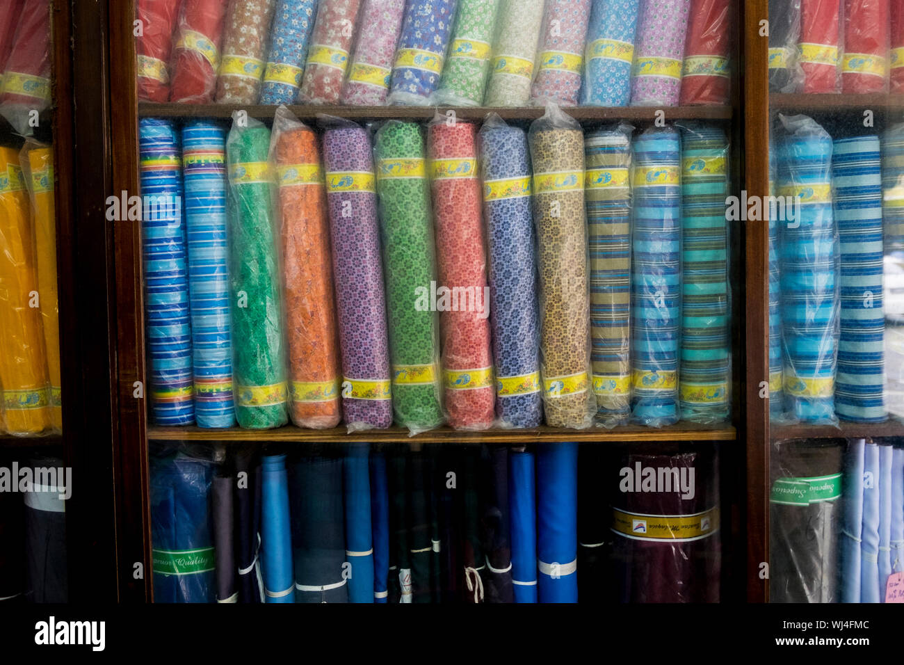 Some of the selection of fabric bolts at a tailor in Ipoh, Malaysia. Stock Photo