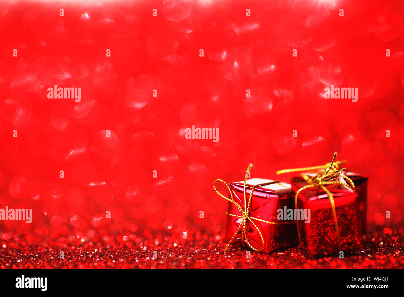 Red Christmas gift boxes on shiny glitter background Stock Photo Alamy
