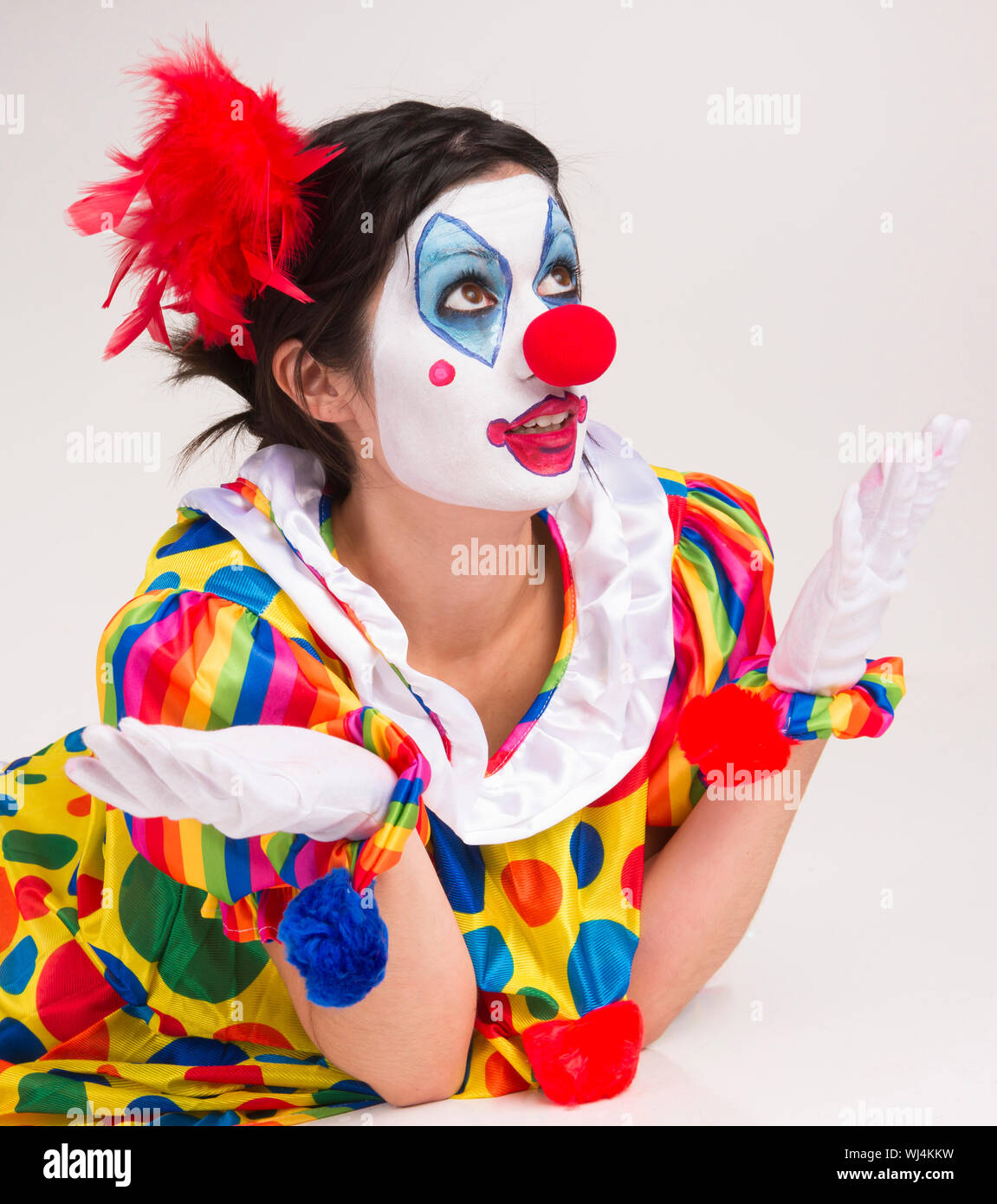 Clown; Circus; Face Paint; Female; Human Role; Behavior; Ecstatic; Cheerful; Studio Shot; Looking At Camera; Entertainment; Red; White; Performer; Iso Stock Photo
