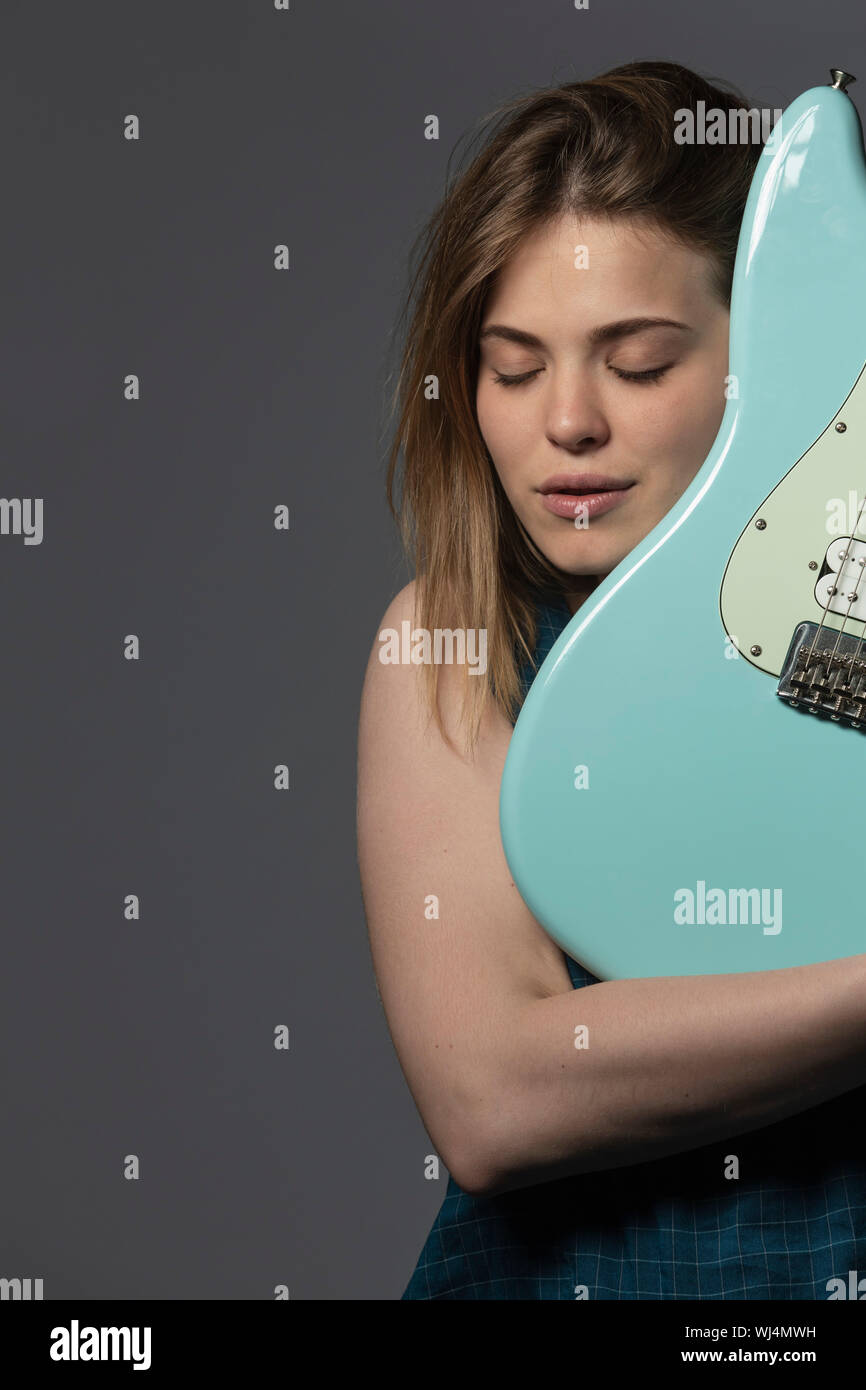 Portrait serene young woman holding electric guitar Stock Photo