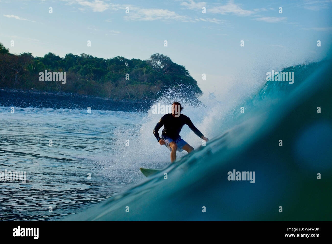 Male surfer riding ocean wave Stock Photo