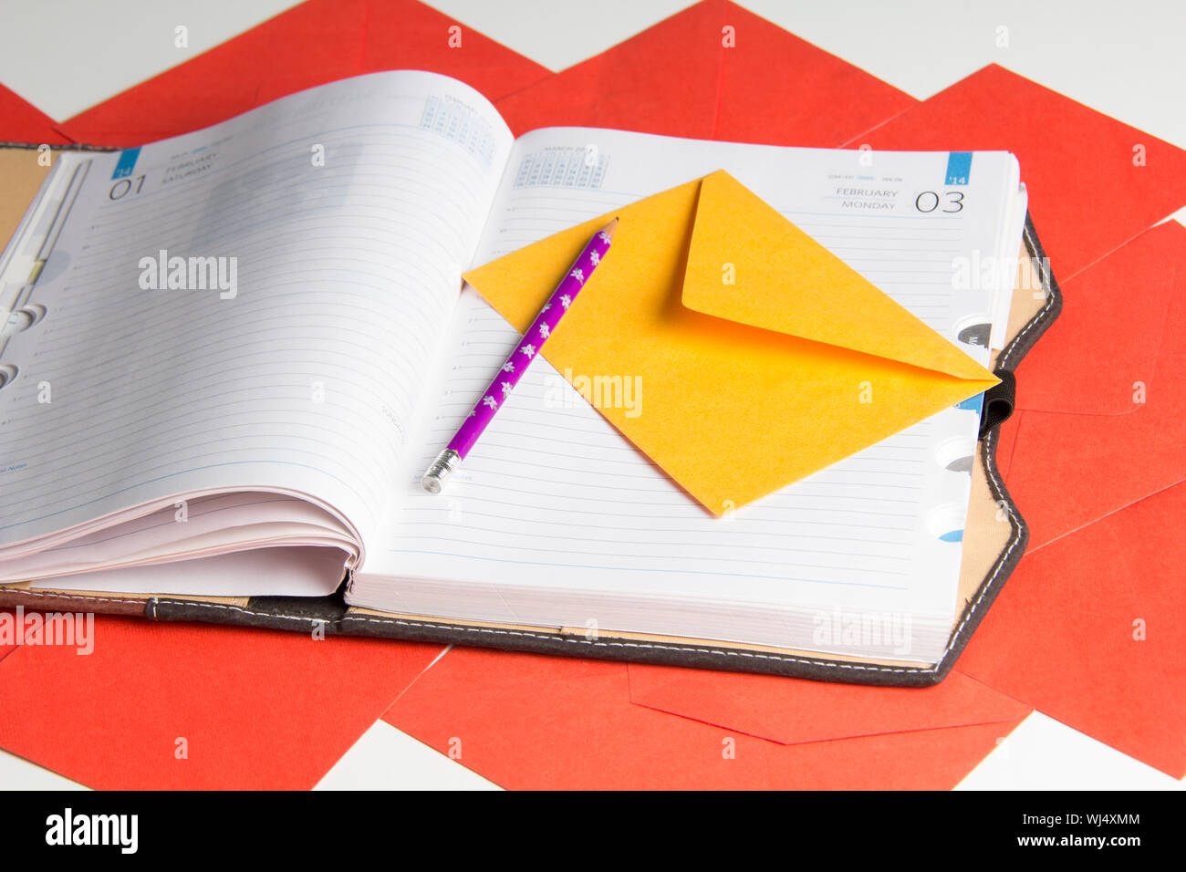 Close up of diary and pencil with envelope Stock Photo