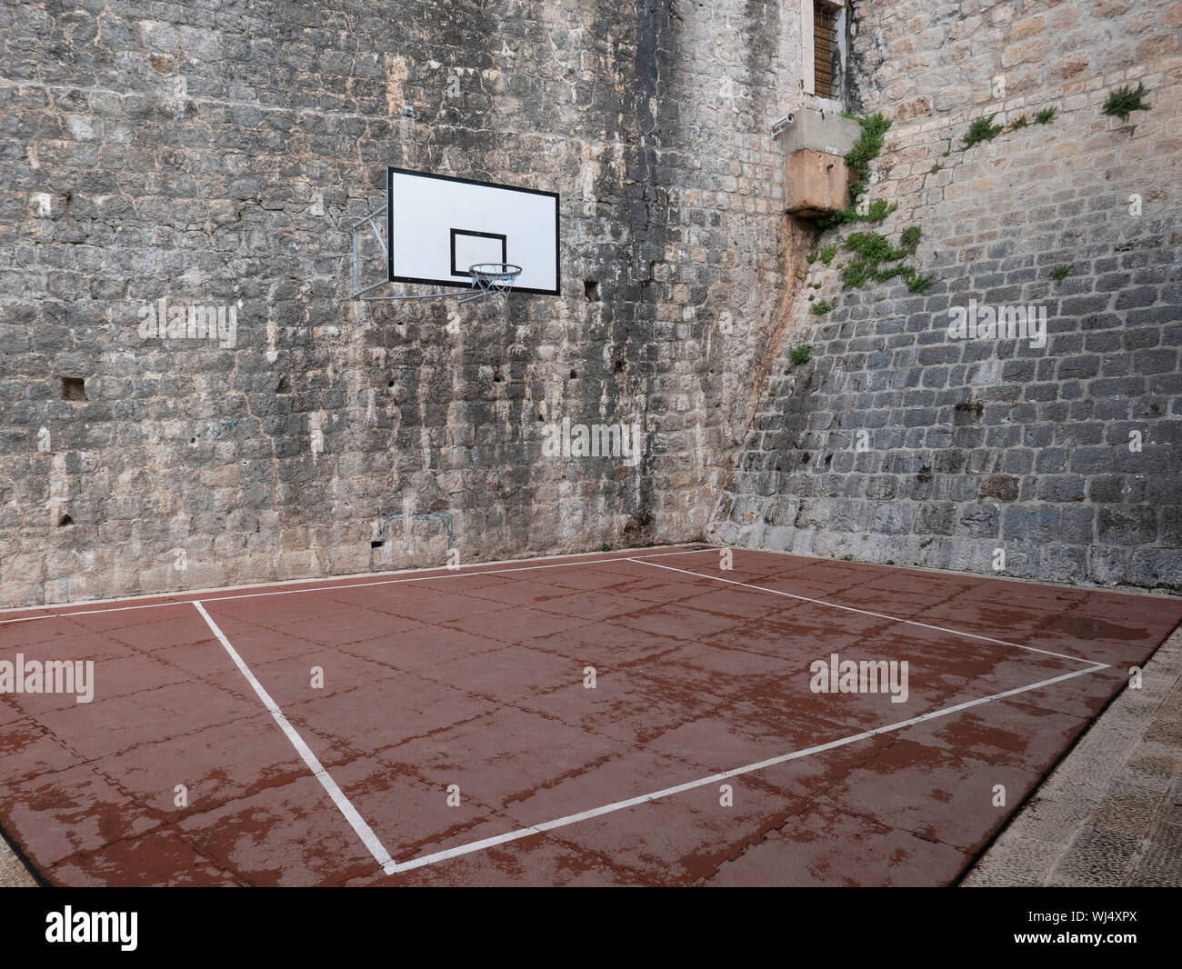 Basketball court and hoop in stone courtyard Stock Photo