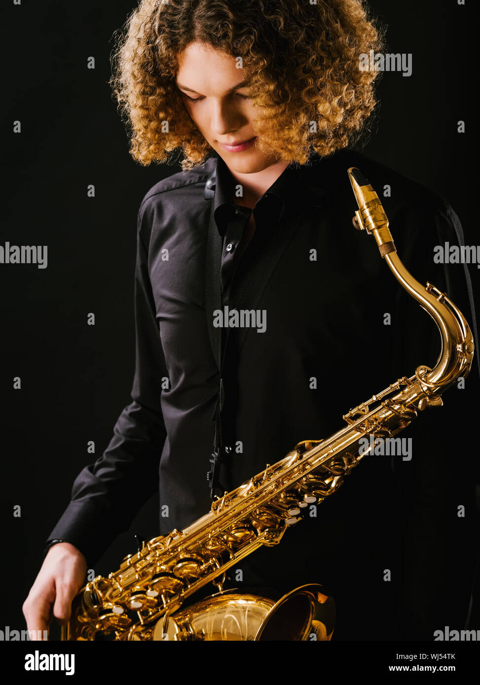 Photo of a teenager and his saxophone. Stock Photo