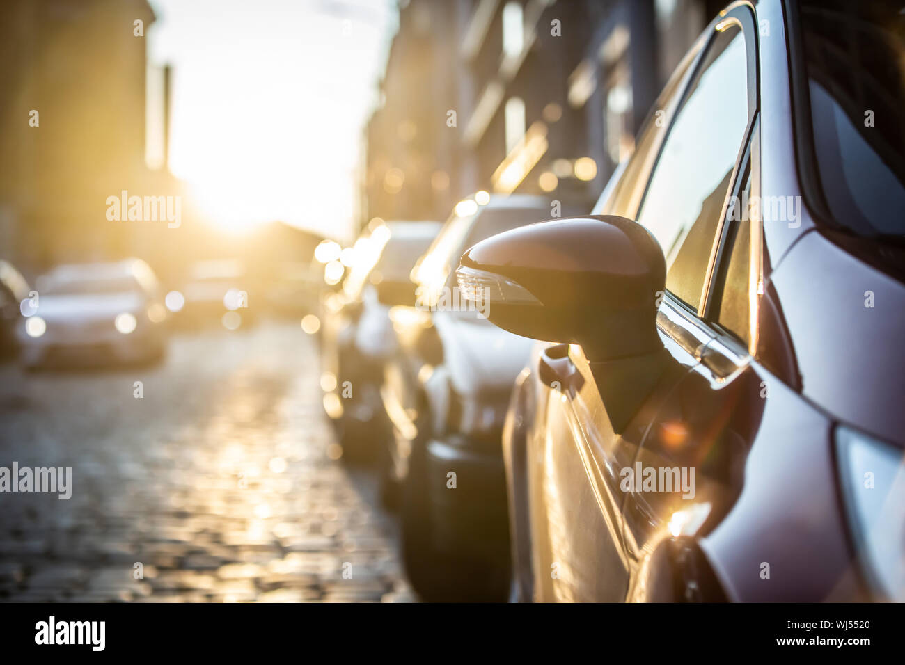Cars parked on the side of the road, with sunset background. Stock Photo