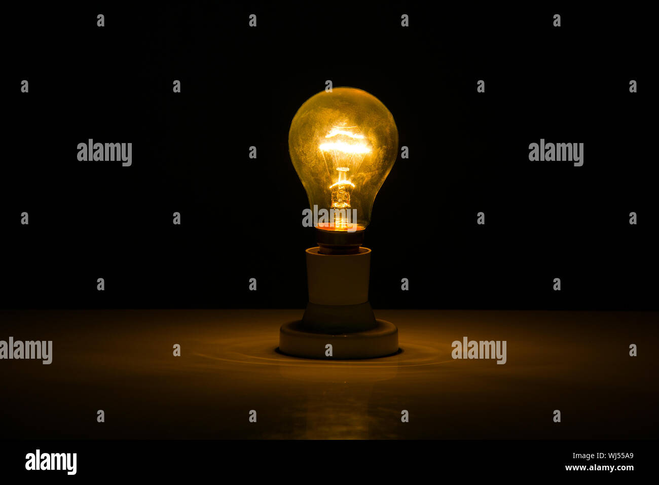 Illuminated light bulb in dark room Stock Photo Alamy