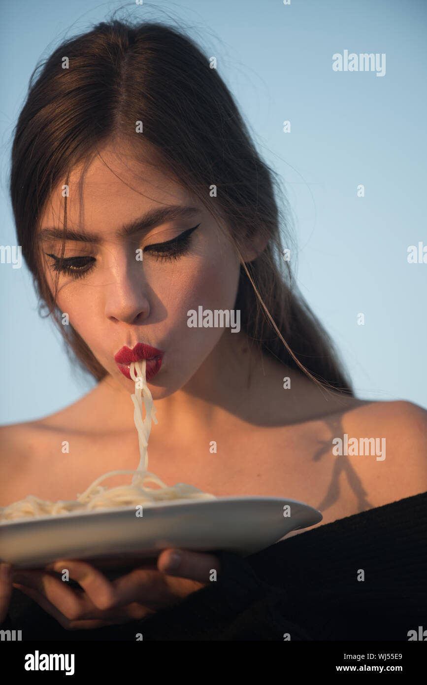 Woman eating pasta as taster or restaurant critic. Italian macaroni or spaghetti for dinner