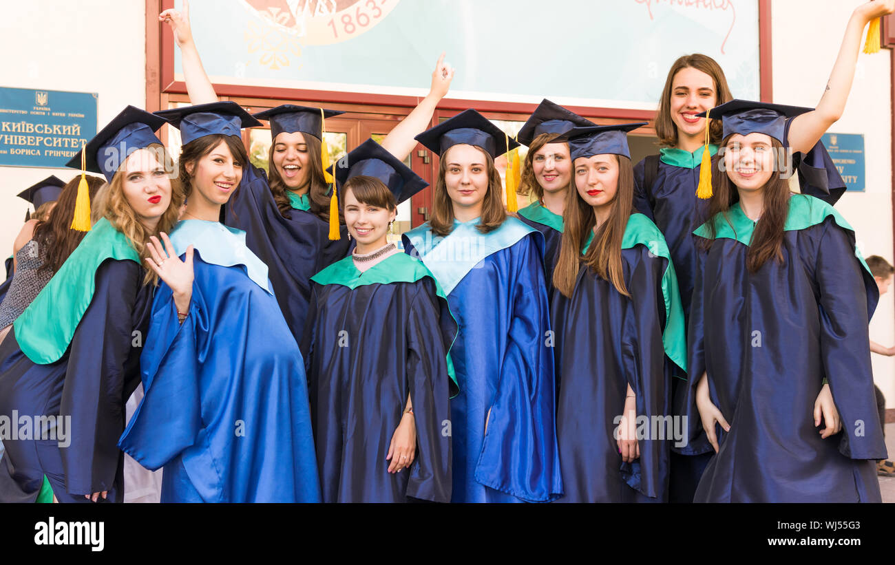 A group of young female graduates. Female graduate is smiling against the background of university graduates. Concept of education, graduation and kno Stock Photo
