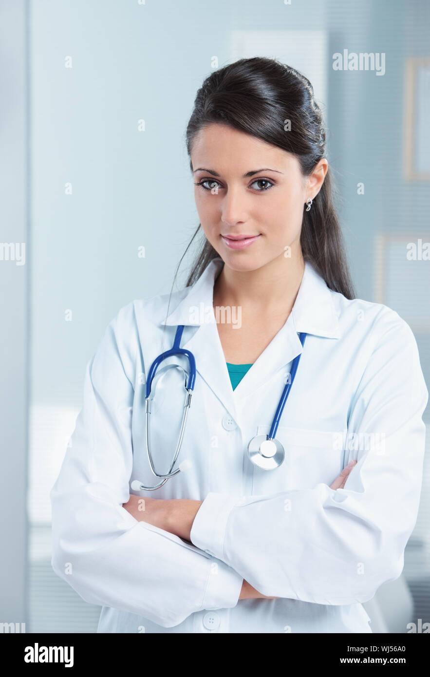 Portrait of a smiling woman doctor with her arms crossed Stock Photo ...