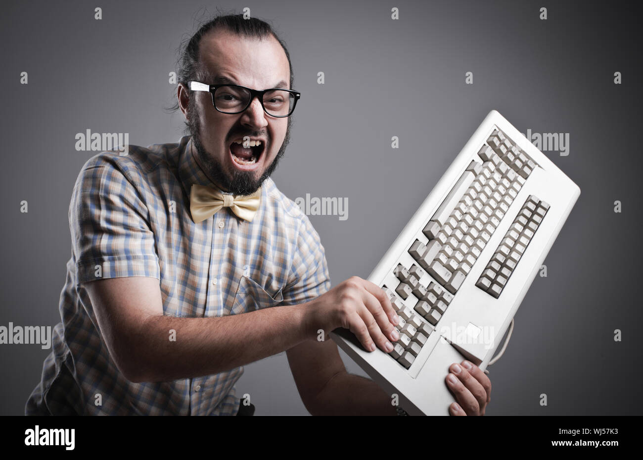 Angry man is destroying a keyboard Stock Photo Alamy