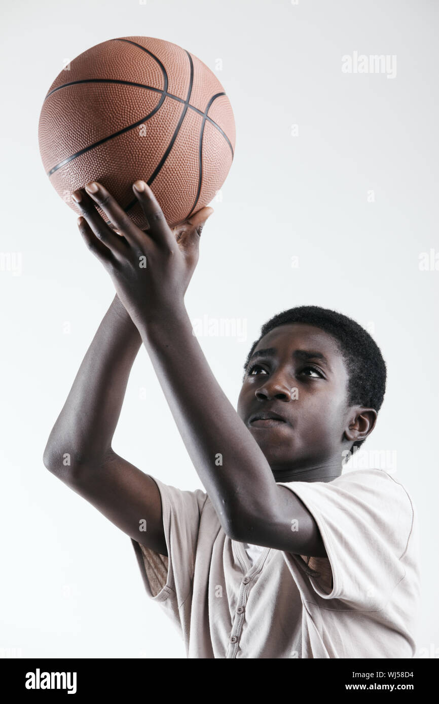 Boy concentrating to shoot a basketball on white background Stock Photo