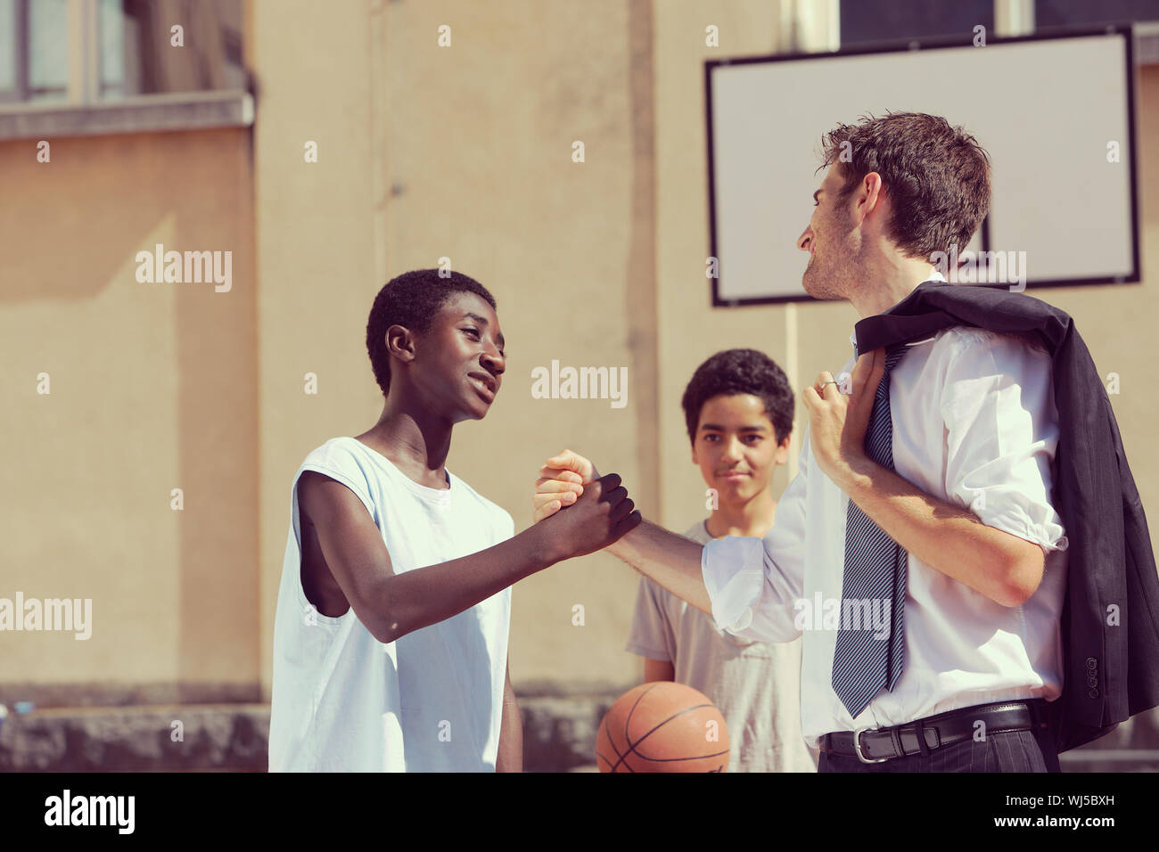 MultiEthnic Basketball players shaking hands after match Stock Photo