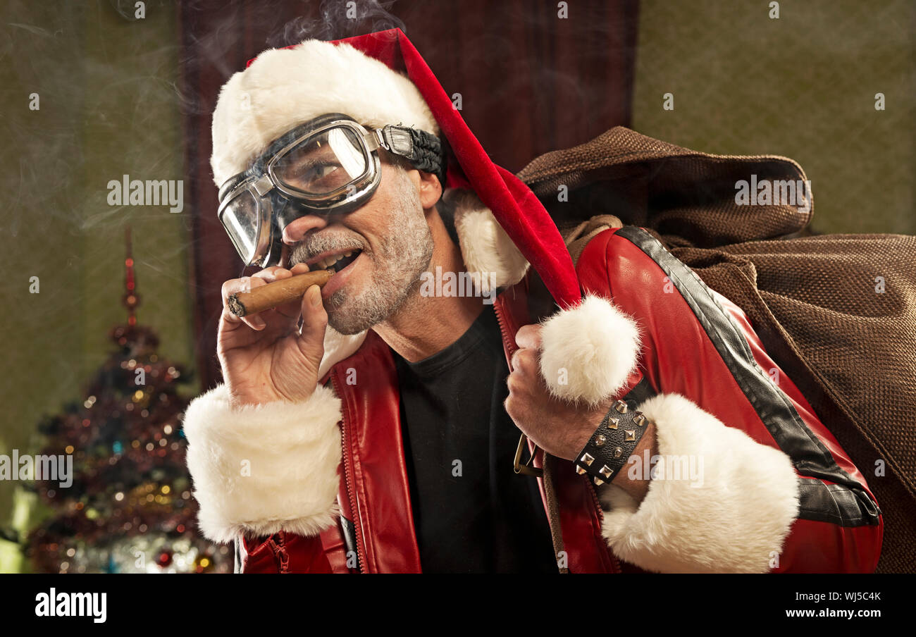 Bad Santa with gift bag smoking cigar Stock Photo
