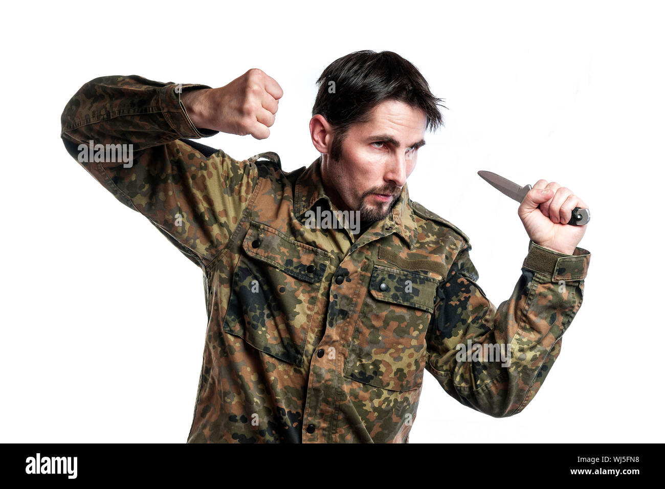 Male self defense instructor with camouflage do a self defense exercise with knife, isolated on white background Stock Photo