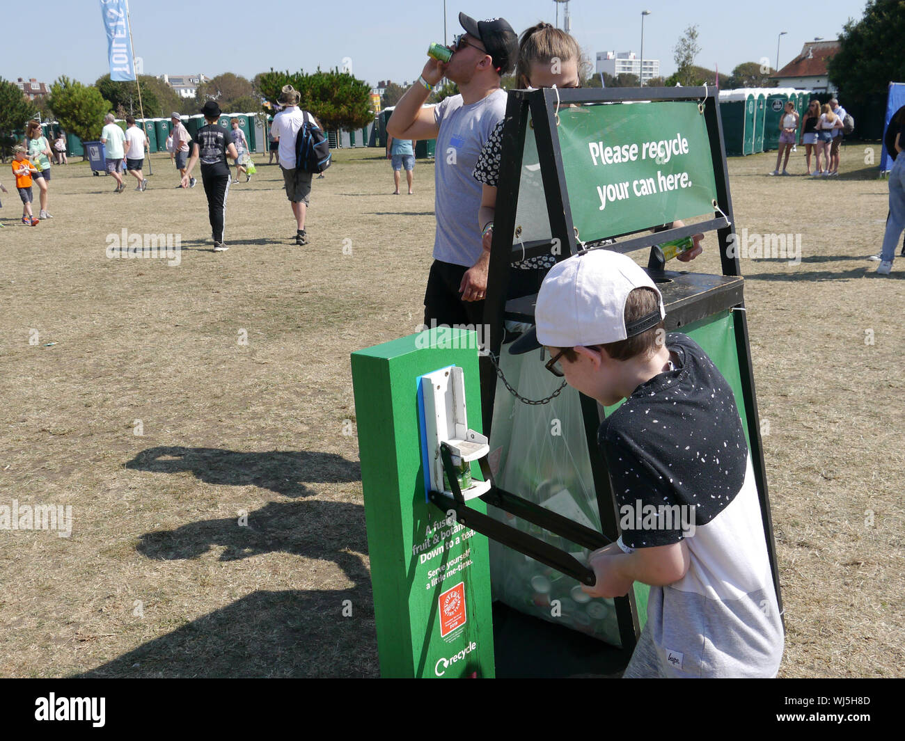 A young boy uses a can crusher and recycling bin. Stock Photo