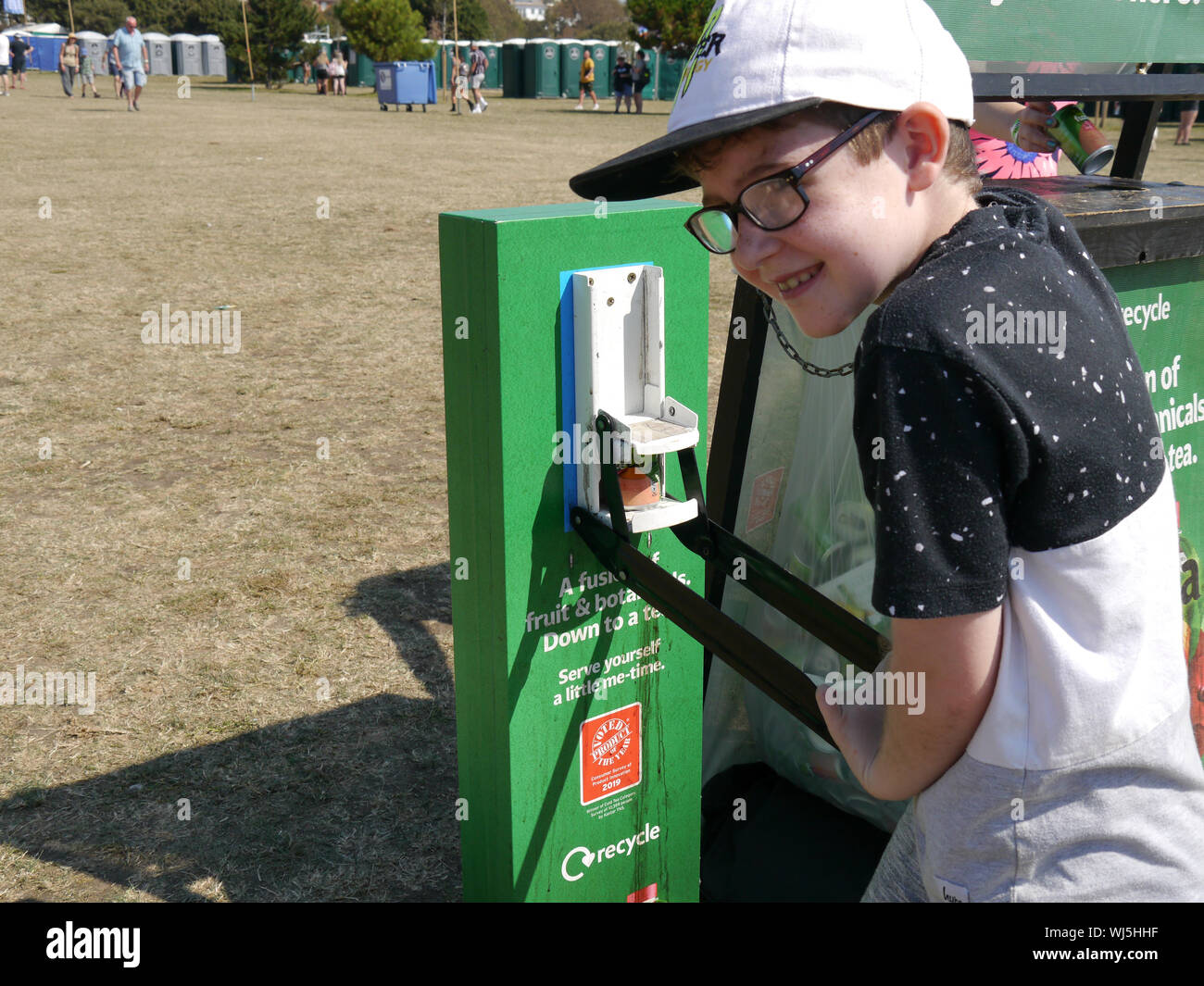 A young boy uses a can crusher and recycling bin. Stock Photo