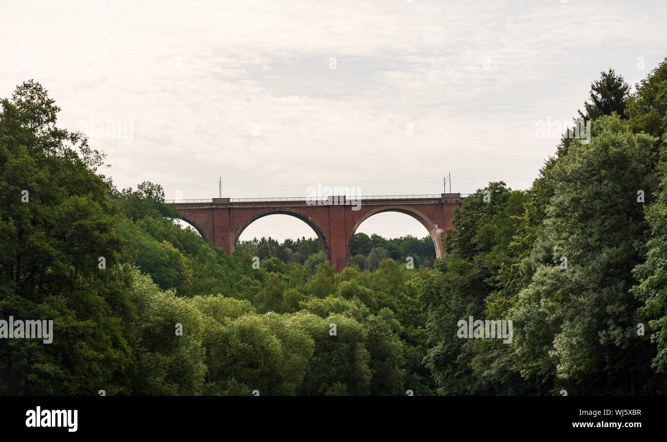 Elstertalbrucke railway brick bridge above Weisse Elster river with trees around near Plauen city in Germany Stock Photo