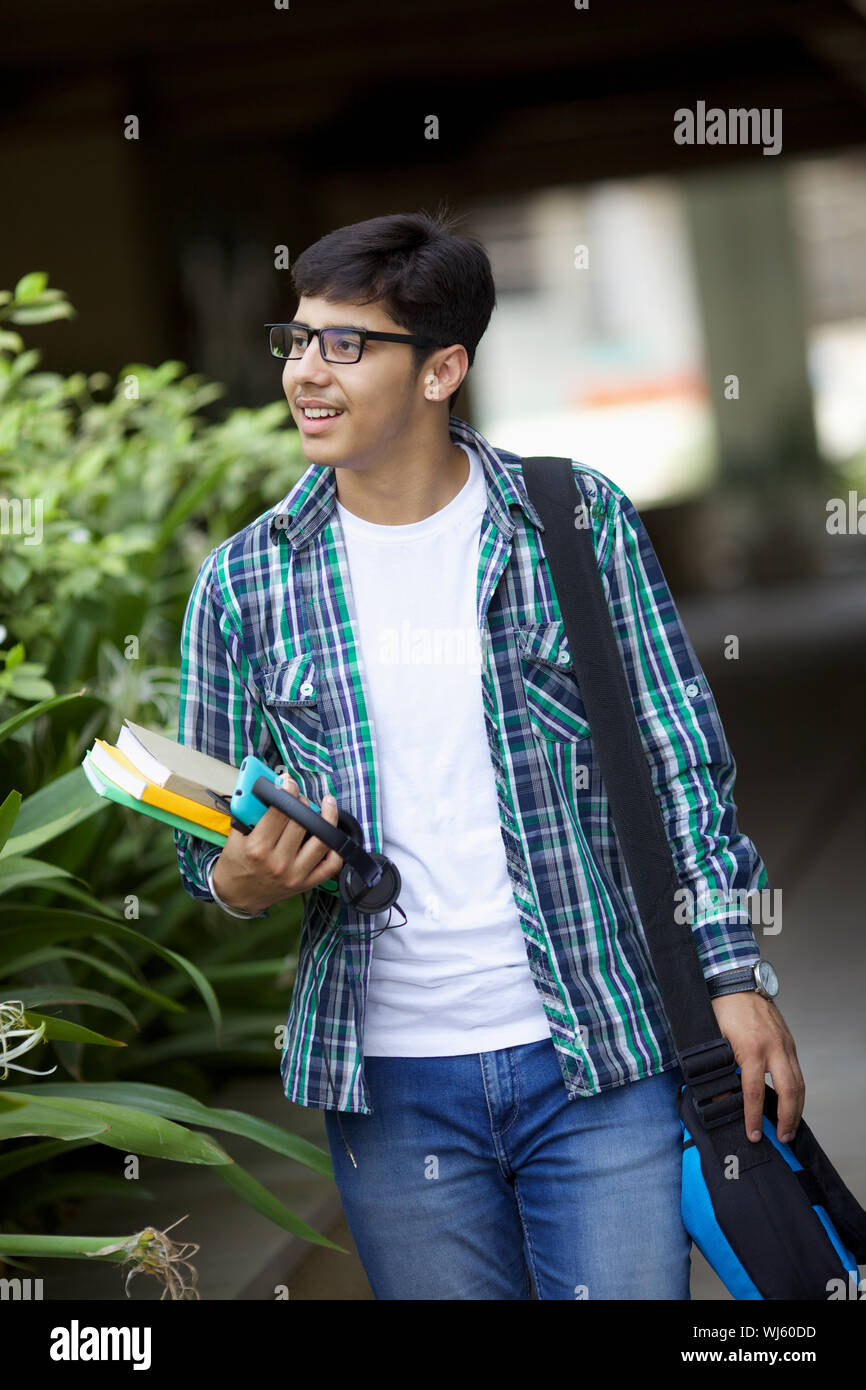 College student walking with books Stock Photo - Alamy