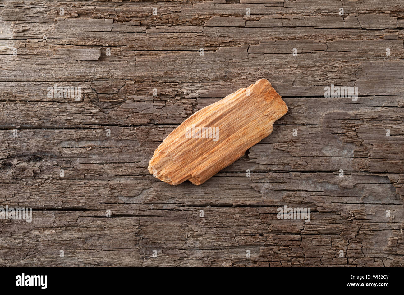 A single alder wood smoking chip for barbecuing on a weathered background. Stock Photo