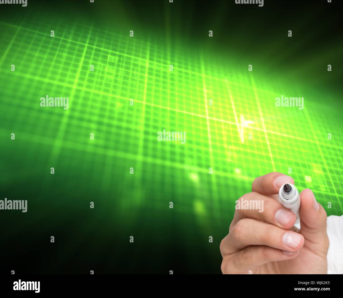 Composite image of businessman writing on camera with a marker pen on black background with green glowing raster Stock Photo