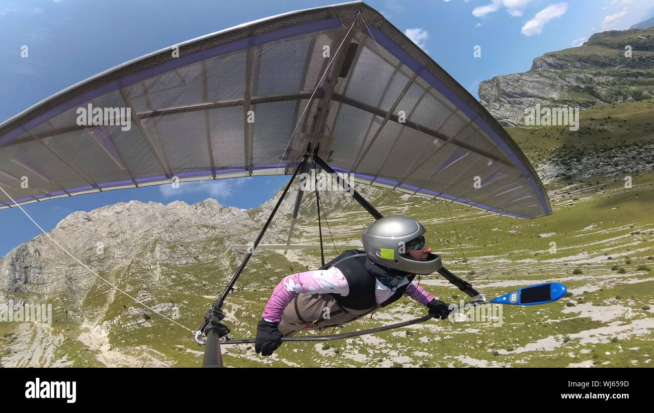 Hang glider pilot flies with his wing between high mountains.  Extreme sport in Soca valley, Slovenia Stock Photo