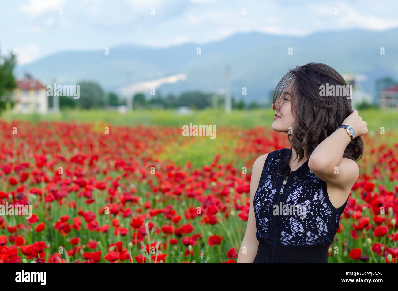 Beautiful girl in poppy field in the summer months Stock Photo - Alamy