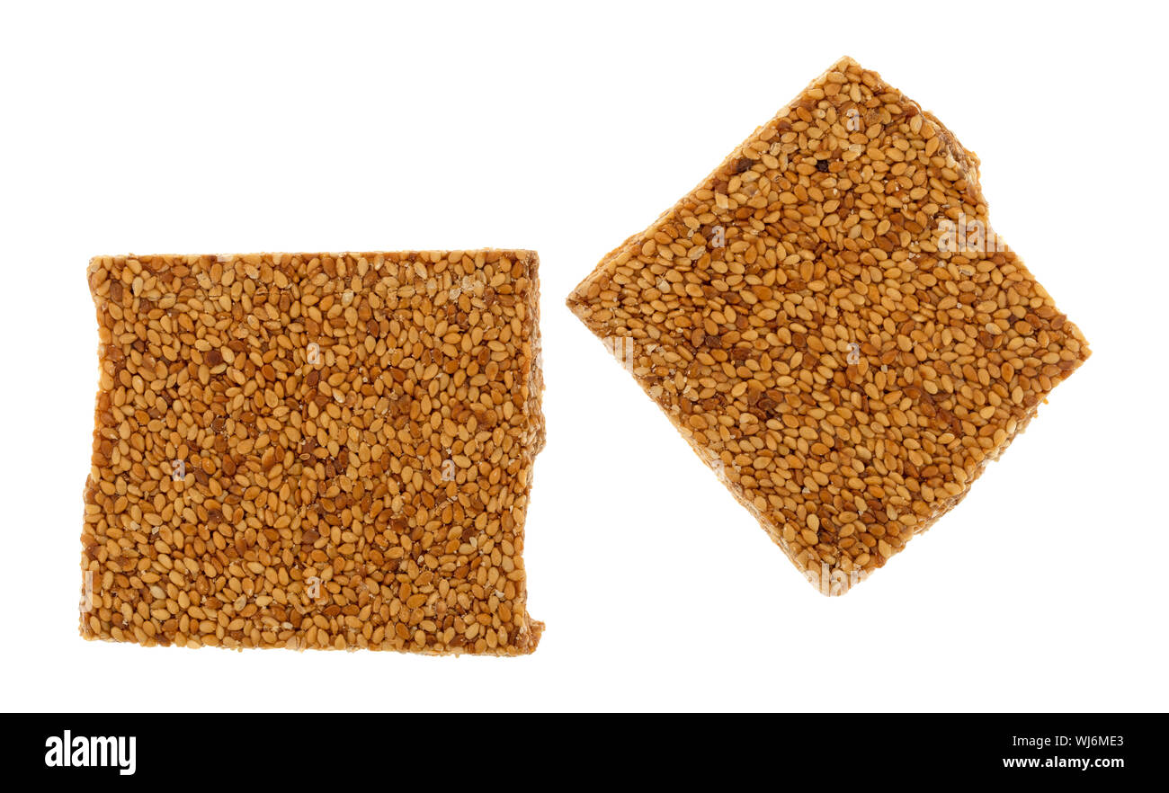 Two pieces of sesame seed crunch candy isolated on a white background