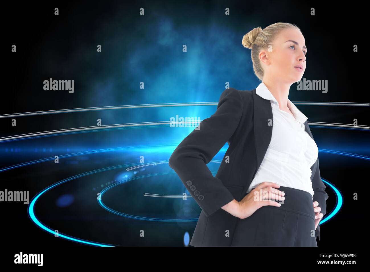 Composite image of blonde businesswoman standing with hands on hips Stock Photo