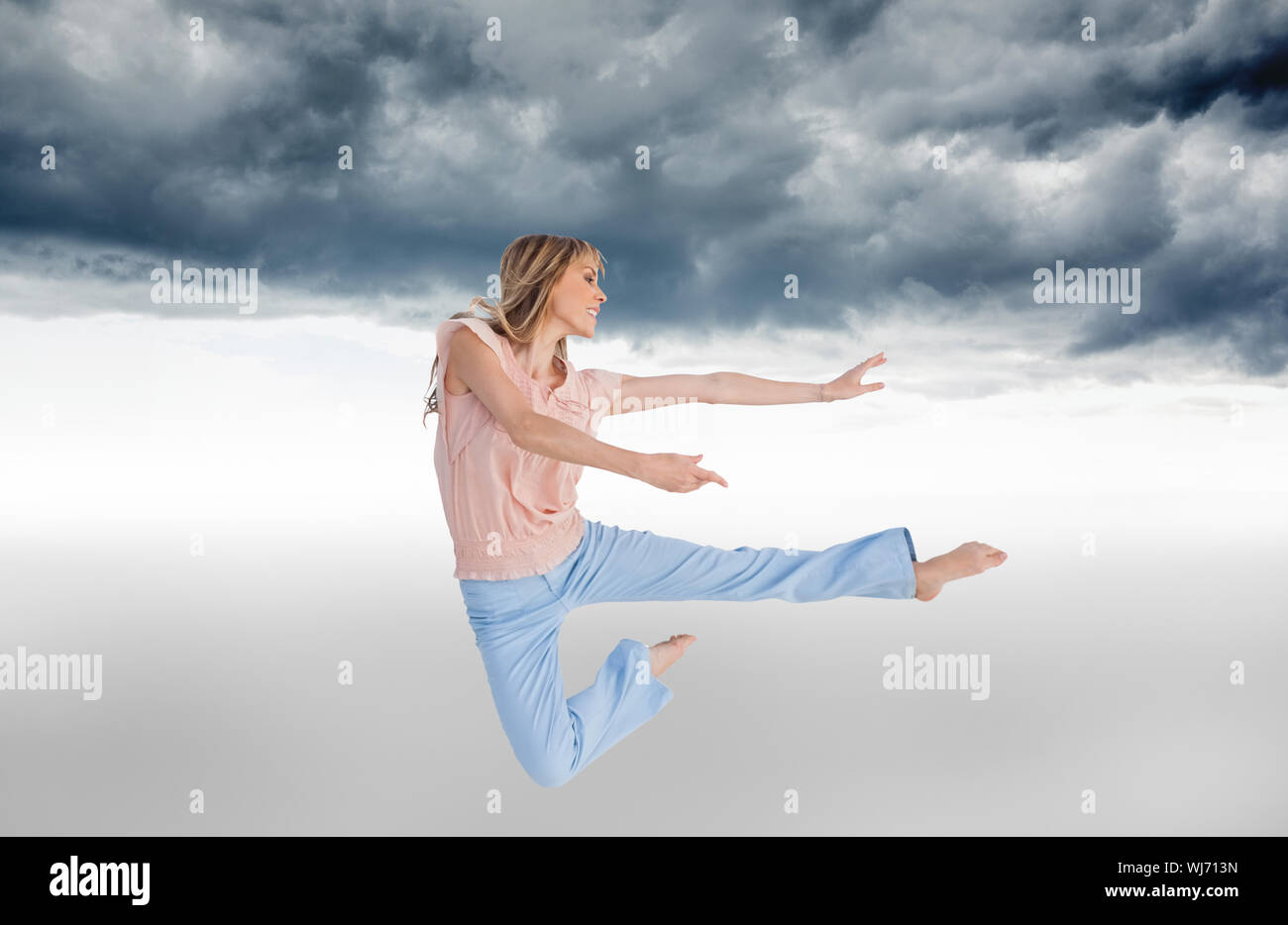 Composite image of woman doing dance pose Stock Photo