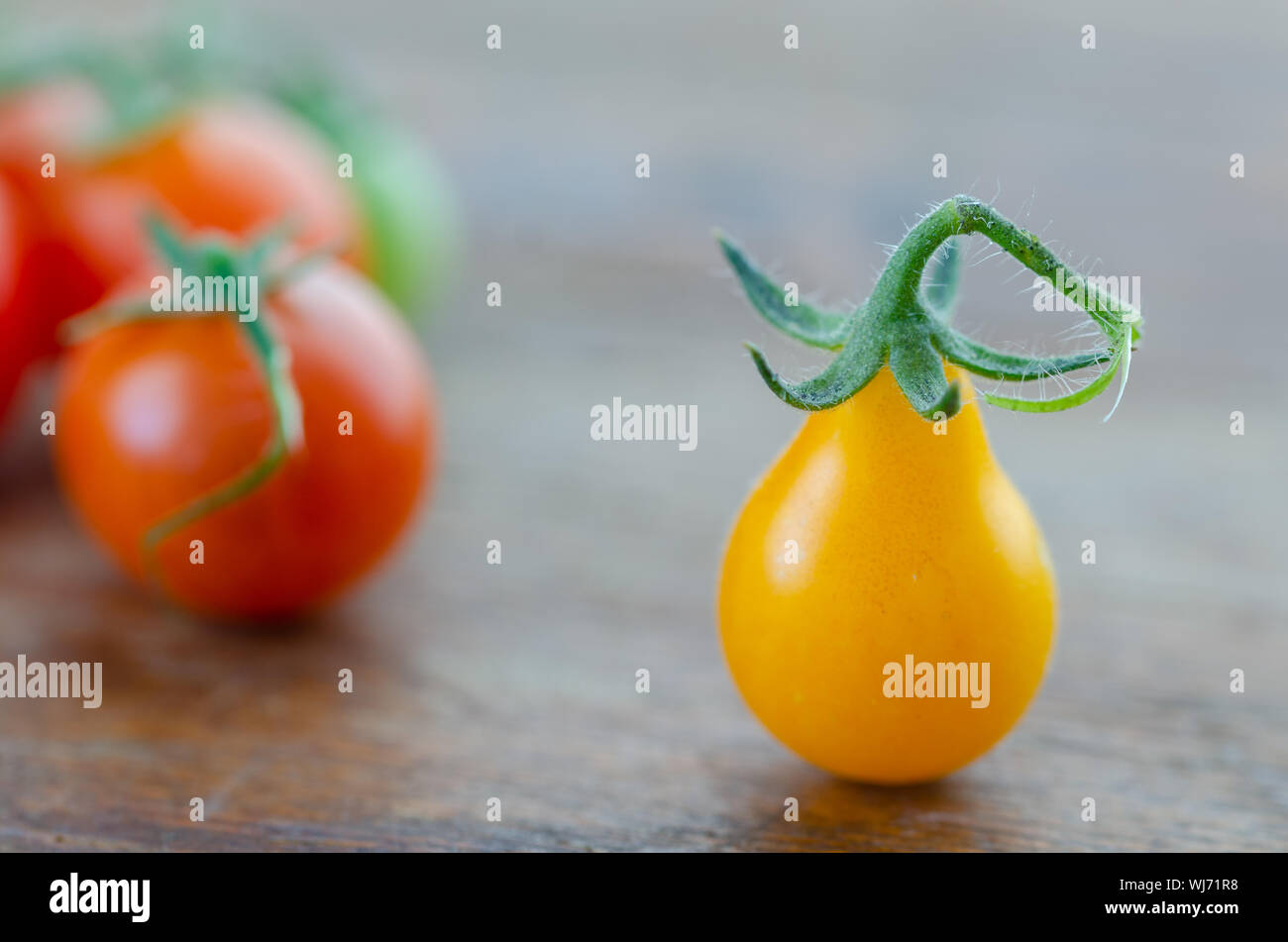 Yellow pear tomato  and red cherry tomatoes on wooden table,close up, Stock Photo