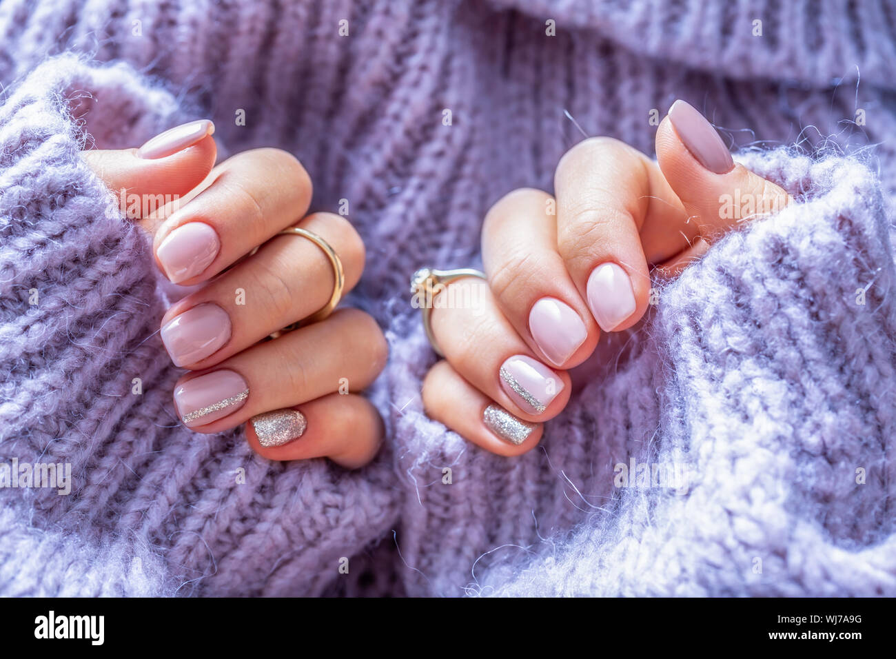 Art nail manicure for bride in purple sweater. Gel nails in soft purple color Stock Photo