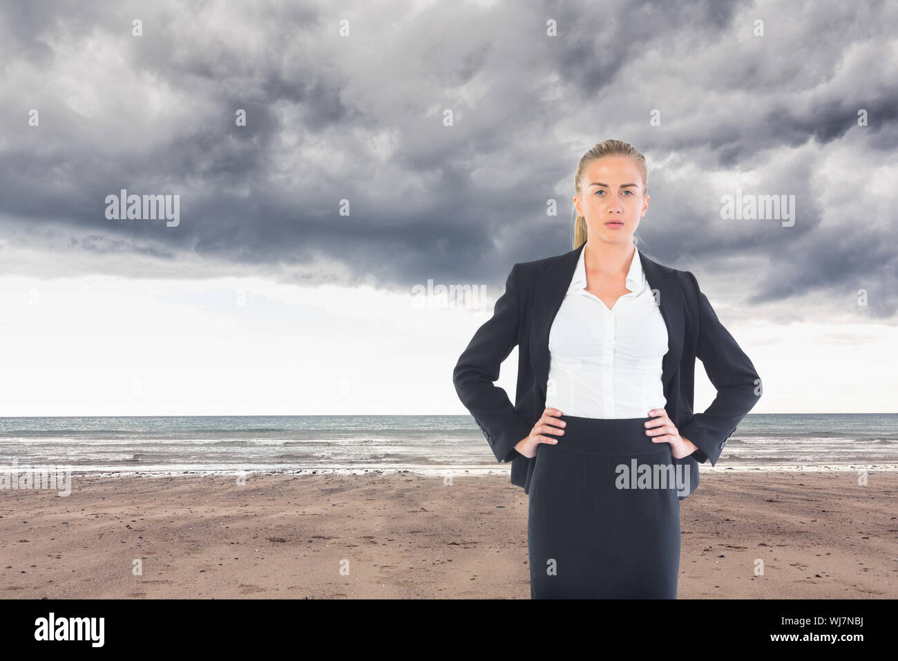 Composite image of blonde businesswoman standing with hands on hips Stock Photo