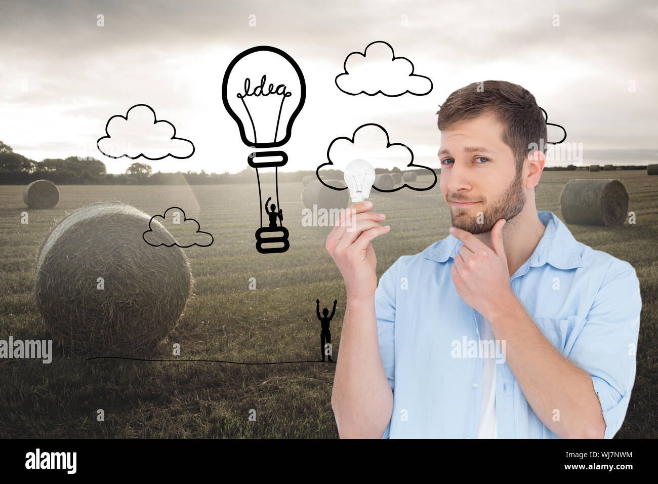 Composite image of handsome model holding a bulb Stock Photo