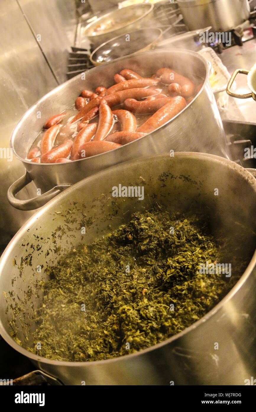 High Angle View Of Kale Leaves And Sausages Cooking In Saucepans Stock Photo