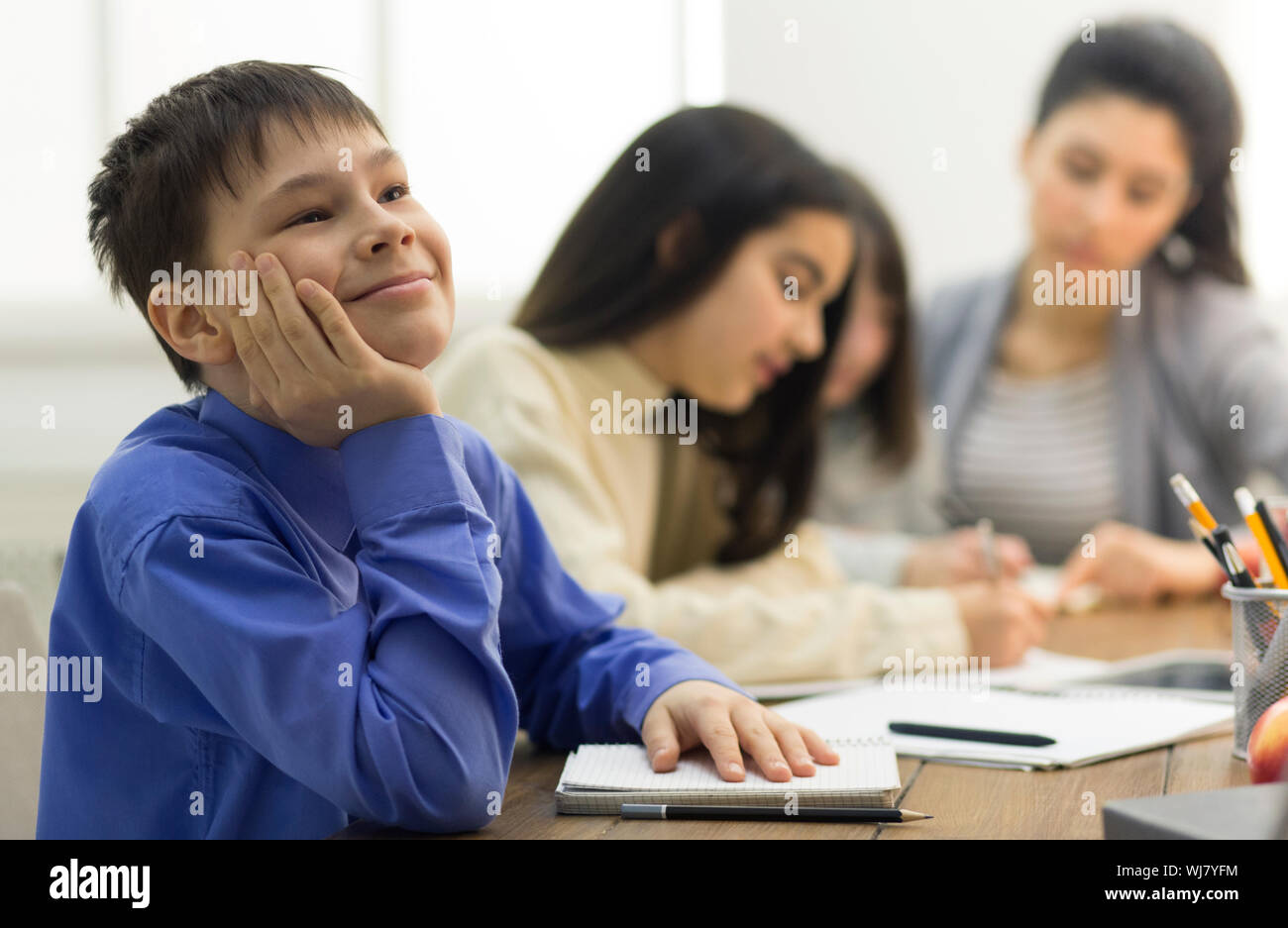Dreamful pupil not paying attention in classroom Stock Photo