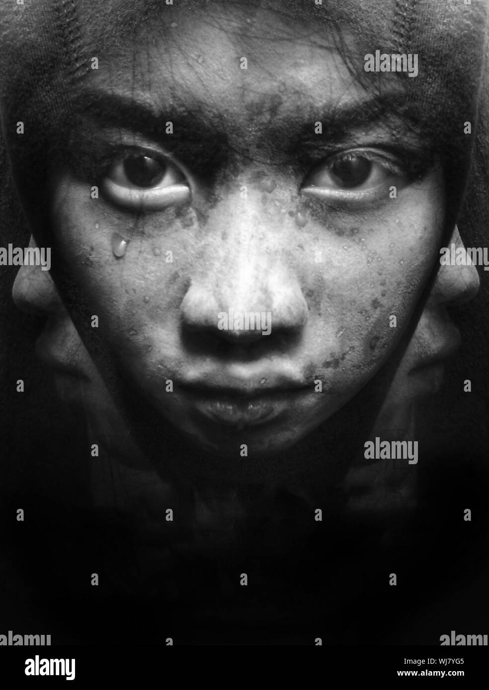 Digital Composite Image Of Teenage Boy With Teardrop Against Black Background Stock Photo
