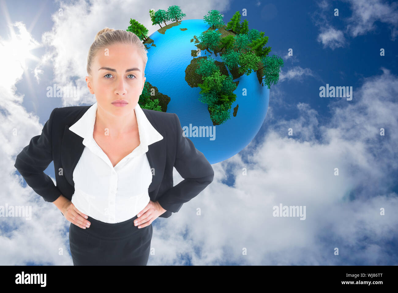 Composite image of blonde businesswoman standing with hands on hips Stock Photo