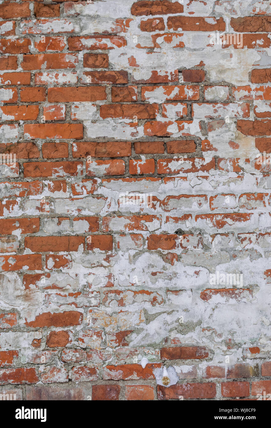 orange wheathered brick wall with snow Stock Photo